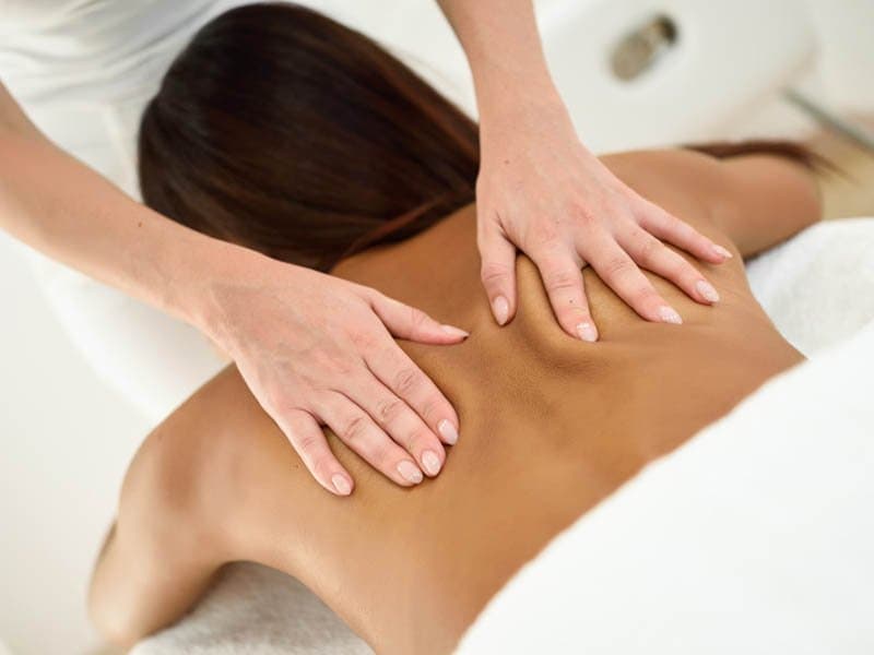 Massage therapist working on a client's shoulders
